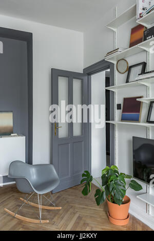 Appartamento con decori grigi, pavimento in legno e il bianco della libreria Foto Stock