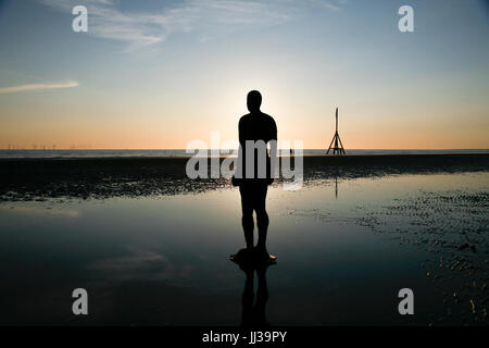 Crosby, UK. 17 luglio 2017. Regno Unito Meteo. Cieli chiari alla fine di un giorno caldo e soleggiato come il sole tramonta su Anthony Gormley "UN ALTRO POSTO' arte di installazione, dotate di ferro rivestito di figure fissate su Crosby beach. Premos/Alamy Live News Foto Stock