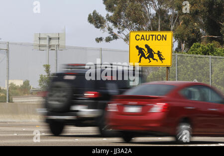 San Ysidro, CA, Stati Uniti d'America. 17 Luglio, 2017. L'ultimo dei dieci immigrati segni di attraversamento che sorgeva su entrambi i lati delle interstatali 5 e Interstate 805 vicino alla US-Messico frontiera è ancora visibile in San Ysidro, CA. Caltrans ha detto che questa ultima non verrà sostituita una volta che esso è andato. I segni sono stati creati sulla base di fotografie scattate dagli ex Los Angeles Times fotografo Don Bartletti e creato da Caltrans dipendente Giovanni cofano nei primi anni novanta dopo troppi decessi si sono verificati sulla superstrada quando il San Diego Pattuglia di Confine settore era letteralmente invasa da migranti crossing. (Credito Immagine: © Giovanni Foto Stock