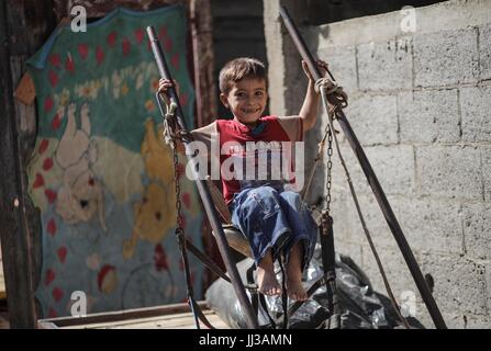 La striscia di Gaza. 17 Luglio, 2017. Un bambino palestinese gioca a al-Shatt campo profughi di Gaza City, il 17 luglio 2017. Le condizioni di vita di due milioni di persone che qui si stanno deteriorando 'ulteriormente e più velocemente la previsione fatta nel 2012 che la striscia di Gaza sarebbe diventato 'unlivable" entro il 2020, un nuovo rapporto delle Nazioni Unite ha trovato di recente. Credito: Wissam Nassar/Xinhua/Alamy Live News Foto Stock