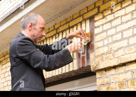 Amburgo, Germania. 18 Luglio, 2017. Artista tedesco Boran Burchhardt copre una proprietà residenziale con golf-foglia nell'Veddel zona di Amburgo, Germania, 18 luglio 2017. Burchhardt coperto ogni mattone della casa in foglia oro come parte di un controverso progetto di arte intitolata "Doratura Veddel". Foto: Daniel Bockwoldt/dpa/Alamy Live News Foto Stock