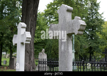 Croce di pietra sulle lapidi del cimitero cimitero / Foto Stock