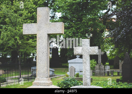 Croce di pietra sulle lapidi del cimitero cimitero / Foto Stock