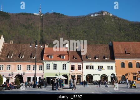 Vista della piazza del Consiglio (Piata Sfatului) con segno di Brasov in montagna, Brasov, Romania Foto Stock
