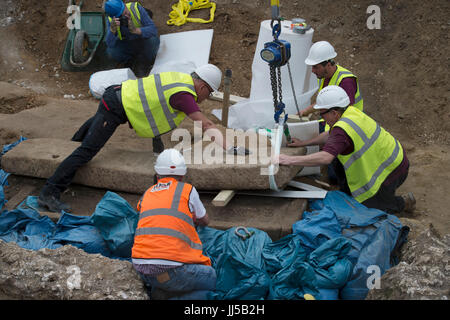 Gli archeologi sollevare il coperchio di un antico sarcofago romano risalente al IV secolo trovata su un sito di costruzione in Swan Street, Southwark, Londra. Foto Stock