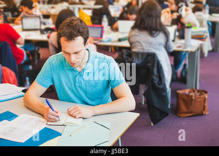 Studente nella grande aula della Biblioteca universitaria Foto Stock