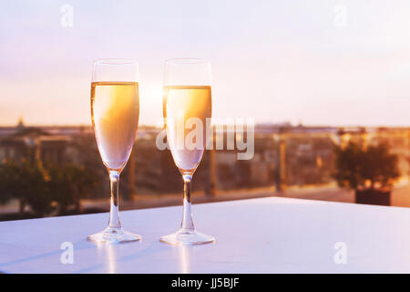 Due bicchieri di champagne al ristorante sul tetto con vista dello skyline della città, lusso cena romantica per le coppie Foto Stock