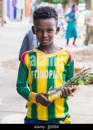 AXUM, Etiopia- Giugno 30, 2016: un ragazzo vendendo mefakia, una naturale in legno usate uno spazzolino da denti in Etiopia. Foto Stock