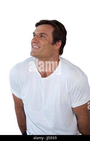 Riflessivo sorridente uomo maturo che guarda lontano contro lo sfondo bianco Foto Stock