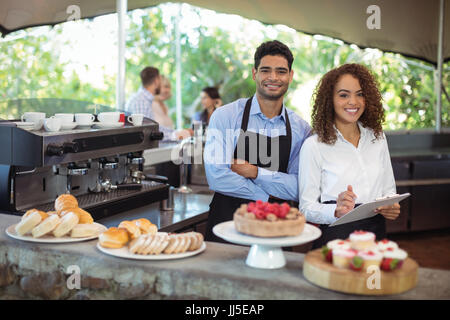 Ritratto di cameriere e cameriera in piedi con gli appunti a contatore nel ristorante Foto Stock