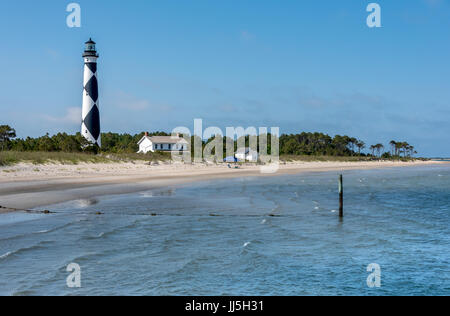 Vista dall'acqua di Cape Lookout Lighthouse w/ bianco e nero diamanti + spiaggia a Harkers isola, Carolina del Nord della costa di cristallo, southern Outer Banks Foto Stock