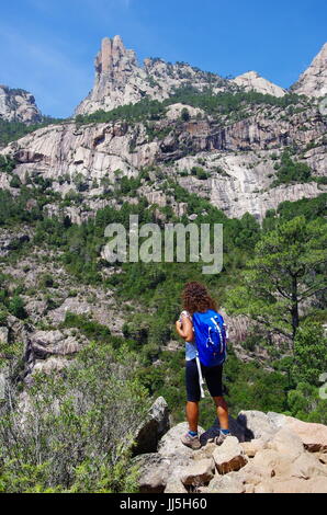 Escursionista femmina (giovane adulto) guardando Punta Lunarda, nell'aiguilles de Bavella gamma. Foto Stock