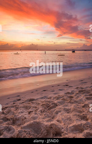 Rosso tramonto sulla Seven Mile Beach in Grand Cayman. Foto Stock