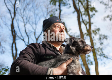 Mark Eccleston e il suo cane Bertie. Egli è un ex segnalatore ferroviario, chi noleggia sette acri di bosco rigenerati a Telford, Shropshire. Regno Unito Foto Stock