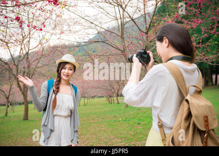 Donna asiatica prendendo foto di amici sorridendo felice con la fotocamera digitale, bellezza moderne, alla moda e fidanzate in vacanze di primavera vacanza sightseein Foto Stock
