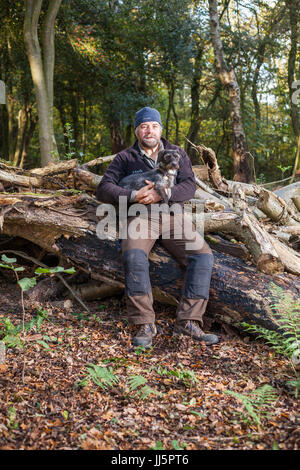 Mark Eccleston e il suo cane Bertie. Egli è un ex segnalatore ferroviario, chi noleggia sette acri di bosco rigenerati a Telford, Shropshire. Regno Unito Foto Stock