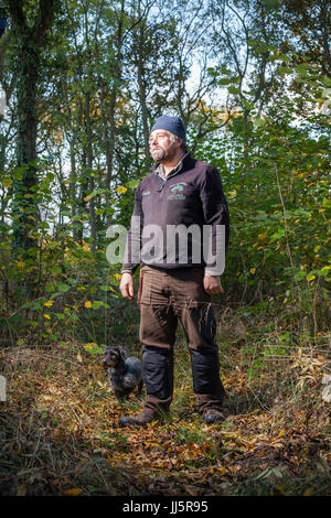 Mark Eccleston e il suo cane Bertie. Egli è un ex segnalatore ferroviario, chi noleggia sette acri di bosco rigenerati a Telford, Shropshire. Regno Unito Foto Stock