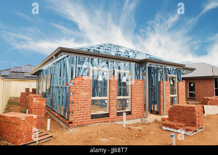 Nuove costruzioni residenziali casa di mattoni con telai metallici contro un cielo blu Foto Stock