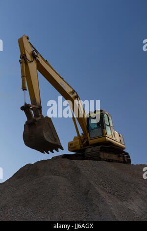 Escavatore giallo lavora con blue sky bakground Foto Stock