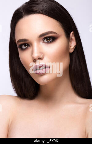 Bella bruna ragazza con una superficie perfettamente liscia e capelli classic make-up. Bellezza viso Foto Stock