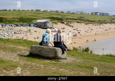 Coppia di anziani sat affacciato sulla spiaggia di Fistra, Newquay Foto Stock