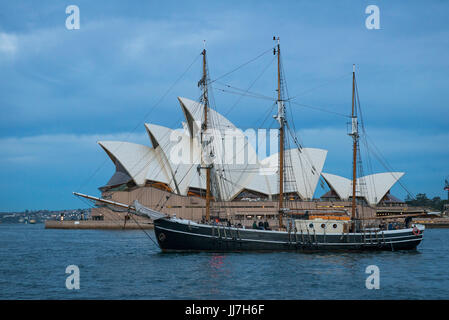 Barca a vela di fronte a Sydney Opera House di Sydney, tramonto, Nuovo Galles del Sud, Australia Foto Stock