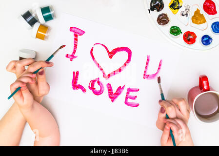 Bambino con le mani in mano di verniciatura di un cuore Foto Stock