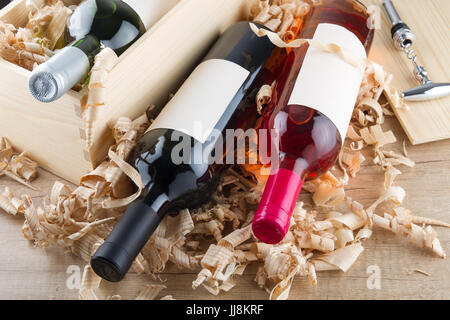 Un assortimento di chiusura di bottiglie di vino che giace sulla paglia e scatola di legno Foto Stock