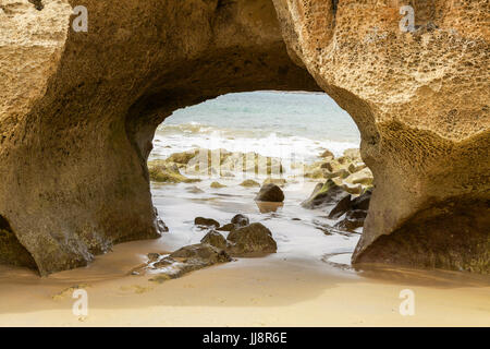 Arco di pietra arenaria sulla spiaggia Foto Stock