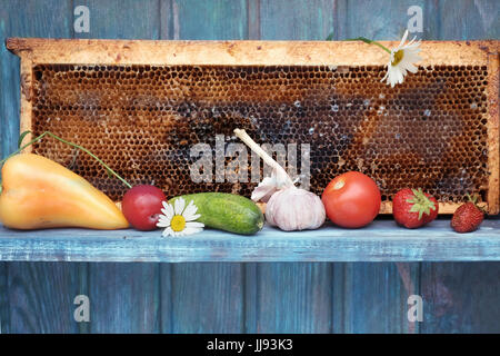 Vari ortaggi e frutta e miele visualizzati sul dipinto ripiano rustico Foto Stock