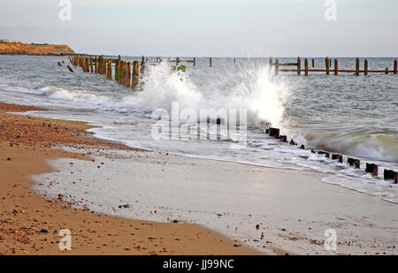 Una vista del mare pounding vecchio le difese del mare tra il carrello e il gap happisburgh, Norfolk, Inghilterra, Regno Unito. Foto Stock