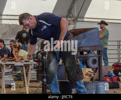 Un concorrente ha 2 ore per creare un set completo di scarpe per un cavallo nel horseshoeing concorrenza a Calgary Stampede. Foto Stock