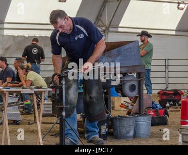 Un concorrente ha 2 ore per creare un set completo di scarpe per un cavallo nel horseshoeing concorrenza a Calgary Stampede. Foto Stock