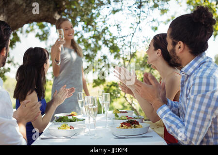 Gruppo di amici di tostatura calici di champagne in un ristorante Foto Stock