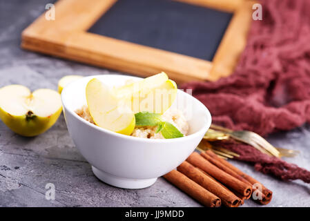 Farina di avena con mele fresche e cannella nel recipiente Foto Stock