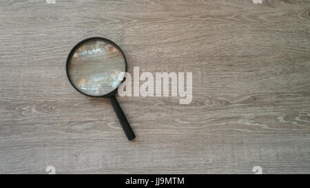 Lente di ingrandimento in laminato grigio Sfondo. Foto Stock