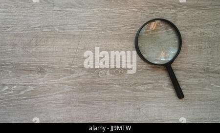 Lente di ingrandimento in laminato grigio Sfondo. Foto Stock