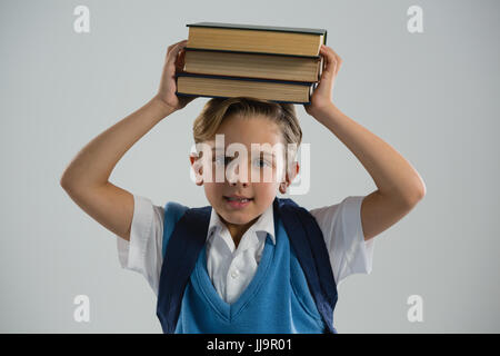 Ritratto di scolaro tenendo il suo libro sulla sua testa Foto Stock