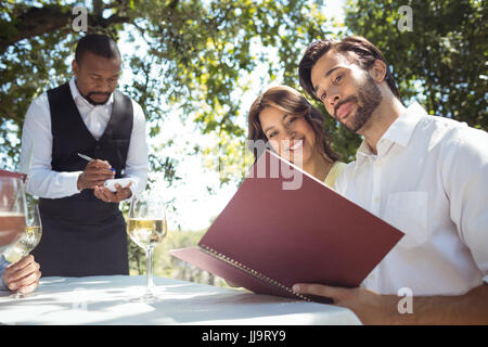 Gli amici mettendo fine al cameriere del ristorante Foto Stock