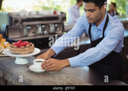 Cameriere che serve il caffè a contatore in cucina commerciale Foto Stock