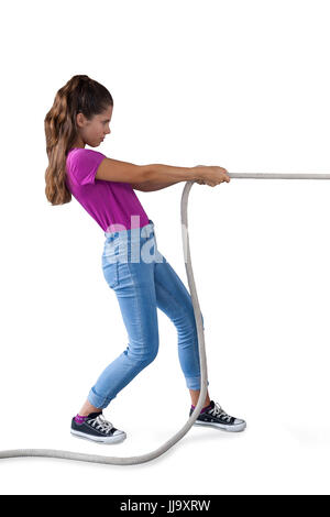Ragazza tirando la fune contro uno sfondo bianco Foto Stock