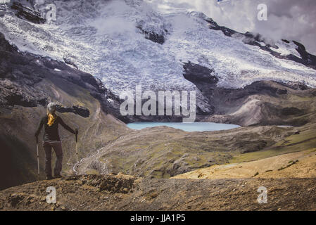 La donna si affaccia Ausangate glaciale gamma di montagna & laghi, Perù Foto Stock