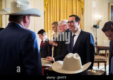 Washington, Stati Uniti d'America. 18 Luglio, 2017. U.S il Segretario al Tesoro Steven Mnuchi, destra, chat con Stetson Hat Presidente Dustin Noblitt, sinistra, durante un Made in America prodotti in vetrina con gli elementi creati in ciascuno dei 50 stati in Oriente stanza della casa bianca Luglio 17, 2017 a Washington, DC. Credito: Planetpix/Alamy Live News Foto Stock