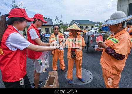 Yuyao cinese della provincia dello Zhejiang. 19 Luglio, 2017. I volontari di inviare i cocomeri e medicina per il garbage collector lavora nella soffocante calore in Yuyao Città, est della Cina di Provincia dello Zhejiang, luglio 19, 2017. Credito: Xu Yu/Xinhua/Alamy Live News Foto Stock