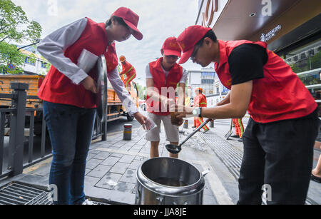 Yuyao cinese della provincia dello Zhejiang. 19 Luglio, 2017. Inviare volontari minestra del fagiolo verde platelayers a lavorare nella soffocante calore in Yuyao Città, est della Cina di Provincia dello Zhejiang, luglio 19, 2017. Credito: Xu Yu/Xinhua/Alamy Live News Foto Stock