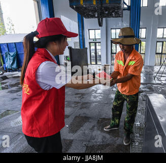 Yuyao cinese della provincia dello Zhejiang. 19 Luglio, 2017. Inviare volontari angurie in un garbage collector lavora nella soffocante calore in Yuyao Città, est della Cina di Provincia dello Zhejiang, luglio 19, 2017. Credito: Xu Yu/Xinhua/Alamy Live News Foto Stock