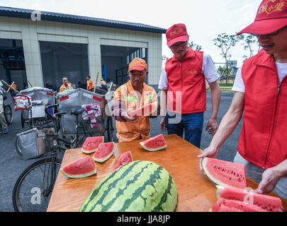 Yuyao cinese della provincia dello Zhejiang. 19 Luglio, 2017. I volontari di inviare i cocomeri al garbage collector lavora nella soffocante calore in Yuyao Città, est della Cina di Provincia dello Zhejiang, luglio 19, 2017. Credito: Xu Yu/Xinhua/Alamy Live News Foto Stock