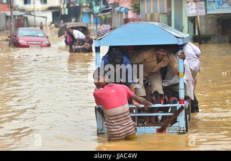 Dimapur, India. 19 Luglio, 2017. Indian Rickshaw Pullers tirare pendolari a terra superiore in un'area inondabile a Dhobinala in Dimapur, India nord orientale di stato del Nagaland. Incessanti piogge monsoniche nella regione per effetto della normale vita causando inondazioni e frane il taglio dell'autostrada nazionale. Credito: Caisii Mao/Alamy Live News Foto Stock