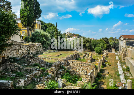 Rovine stradale ad Atene in Grecia con una chiesa greca su una collina che si affaccia sulla città Foto Stock