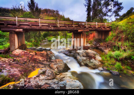 Fast fiume di montagna che scorre sotto il ponte nella remota area agricola della australiano del Nuovo Galles del Sud - Barrington Tops. Caldo giorno d'estate con lieve li Foto Stock